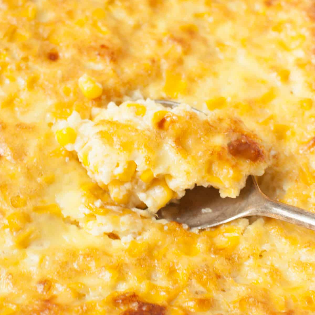 A spoon scooping corn pudding.
